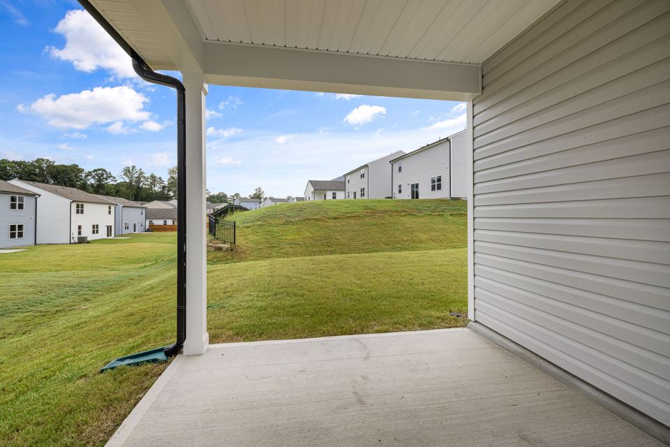 Covered concrete patio beside a lawn, representative residential setting
